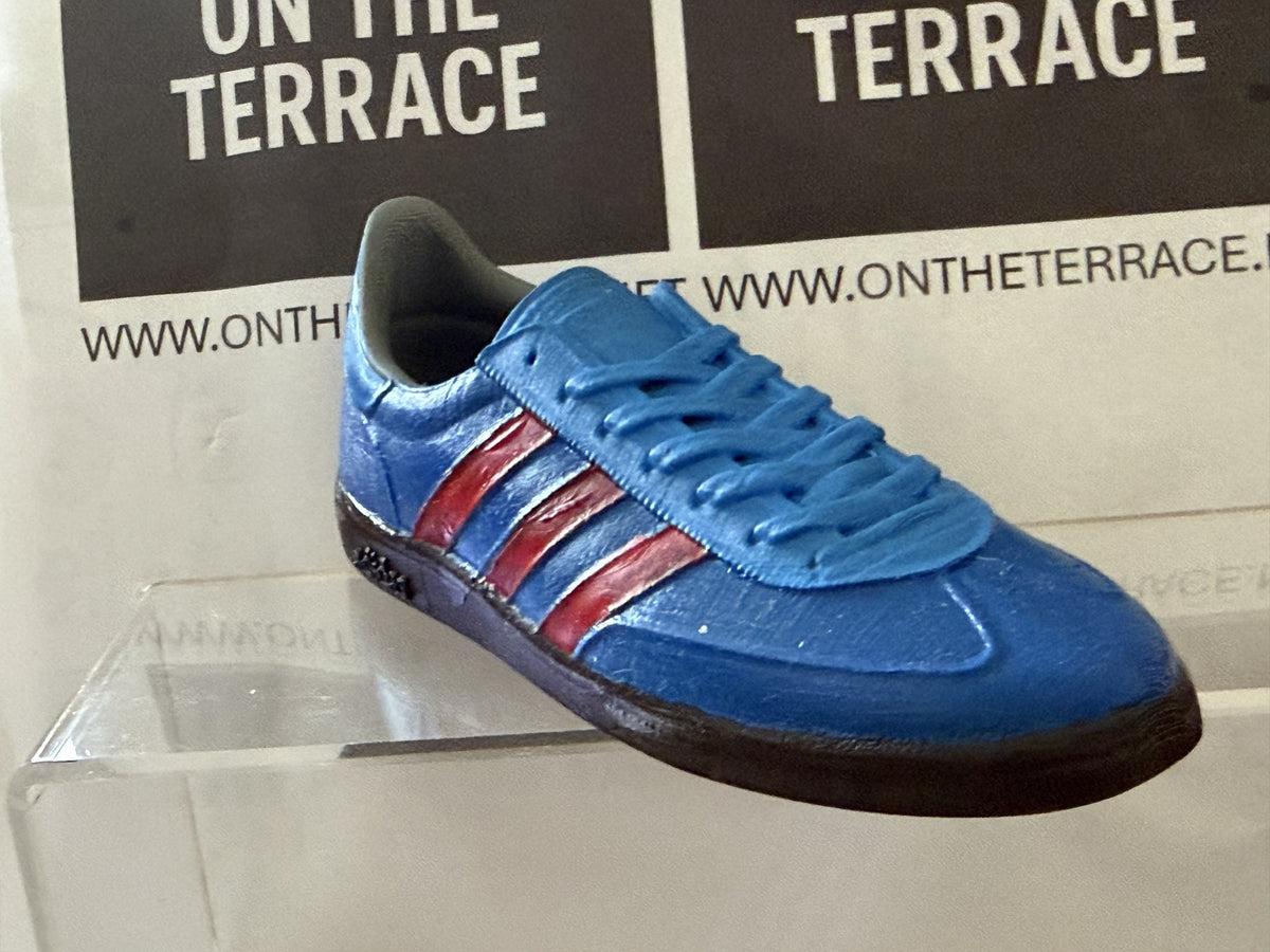 Blue and red painted Manchester inspired 120 mm trainer model, front three-quarter view