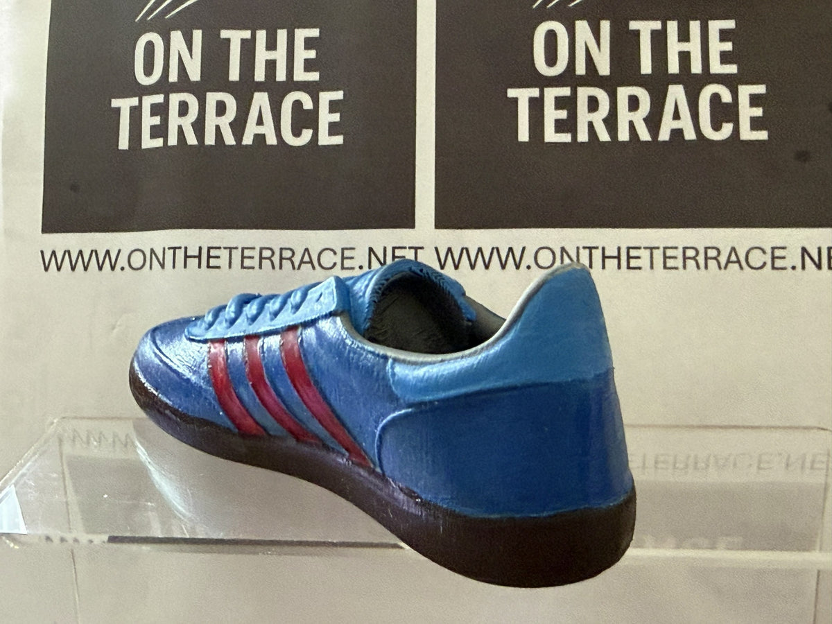Blue and red painted Manchester inspired 120 mm trainer model, rear three-quarter view