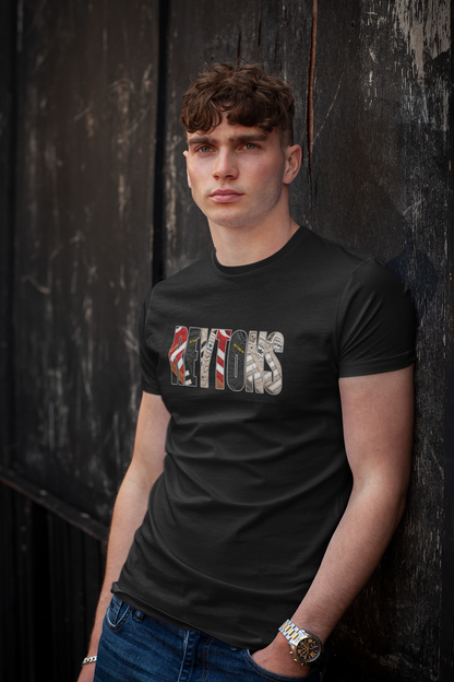 A man wearing a black short-sleeve Reytons t-shirt with a camouflage graphic spelling 'Reytons' across the chest, leaning against a dark wooden wall.