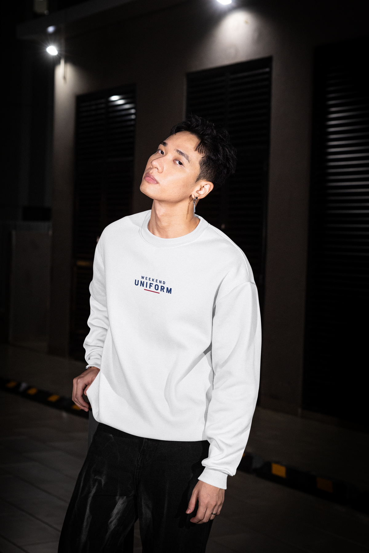 Man at night wearing the white Weekend Uniform football casuals sweatshirt