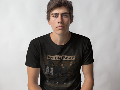 A young man wearing a black graphic swfc t-shirt with a vintage-style illustration and the word 'WEDNESDAY' printed across the chest, set against a plain light gray background.